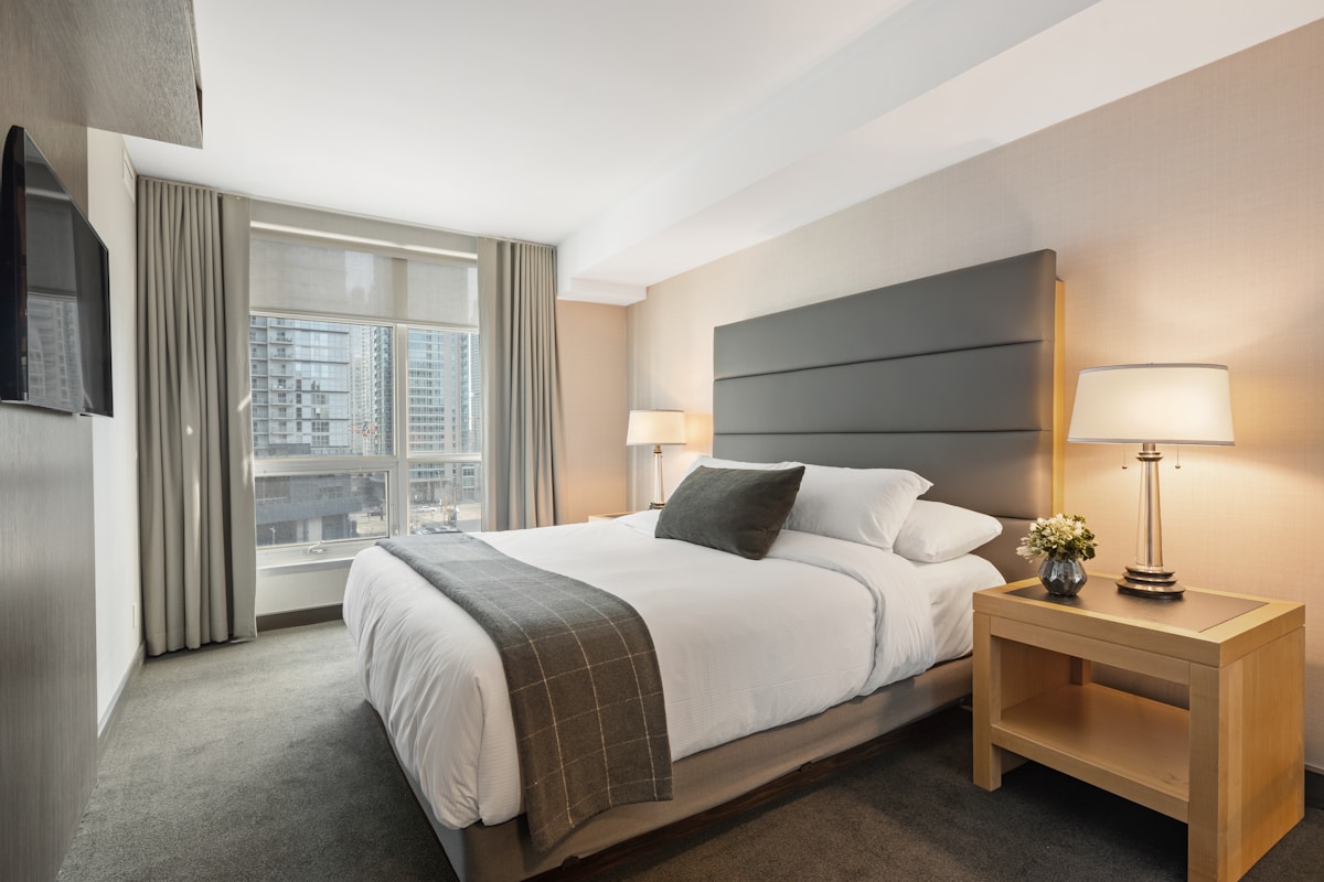 A made-up bed with a supportive mattress in a bright bedroom - best mattress for heavy people UK 2026