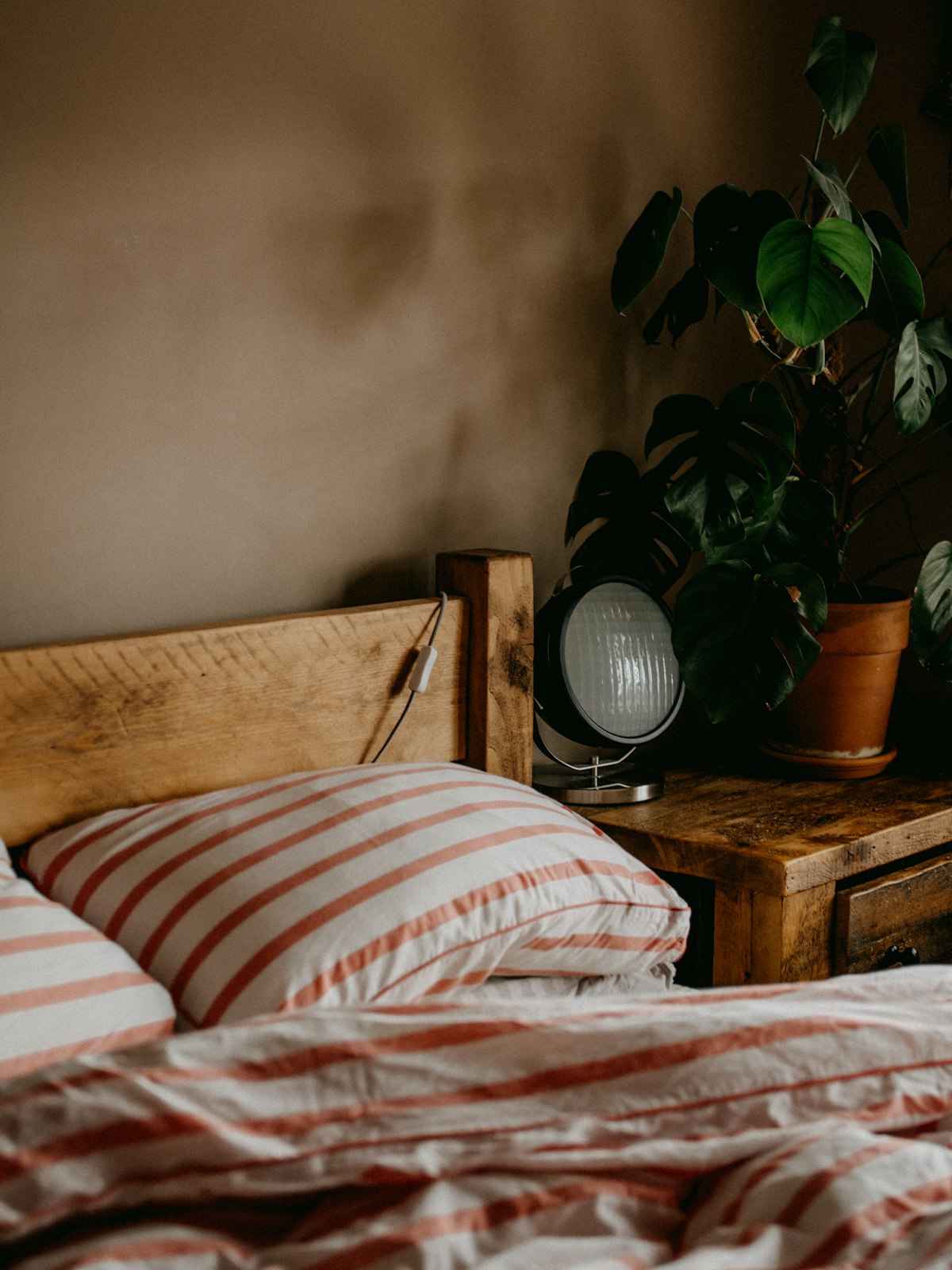 Bed with light summer bedding in a bright bedroom - cheap ways to sleep cool in a UK heatwave