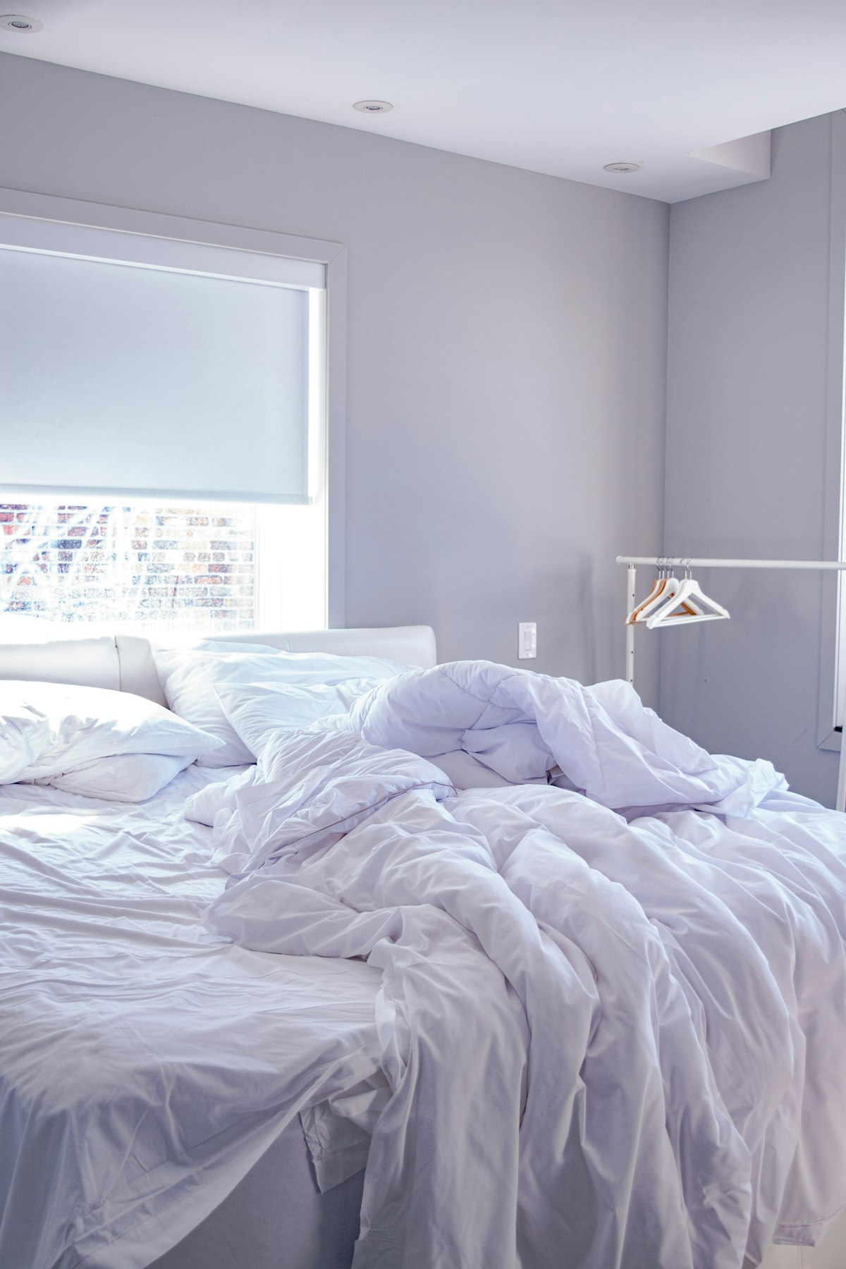 A bed made up with light breathable white bedding - cool bed setup for hot sleepers UK guide